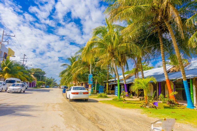Puerto Morelos, México - 10 de enero de 2018: La vista al aire libre de algunas casas con muchos coches parqueó en la calle de Pu fotos de archivo libres de regalías Puerto Morelos, México - 10 de enero de 2018: La vista al aire libre de algunas casas con muchos coches parqueó en la calle de Pu fotos de archivo libres de regalías