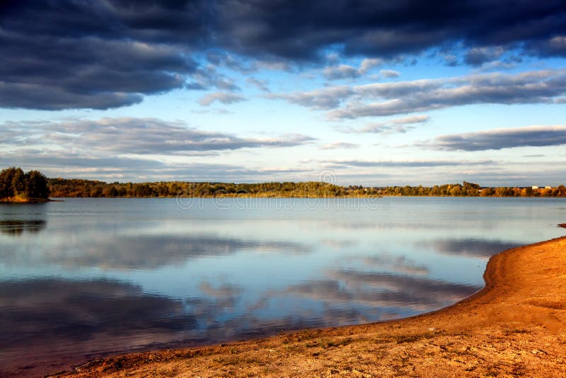 Puesta del sol brillante hermosa en el lago en el otoño, reflec de las nubes imagen de archivo Puesta del sol brillante hermosa en el lago en el otoño, reflec de las nubes imagen de archivo