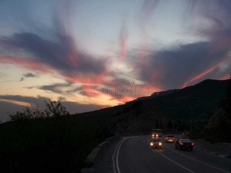 Puesta del sol, camino y coches fotografía de archivo libre de regalías Puesta del sol, camino y coches fotografía de archivo libre de regalías