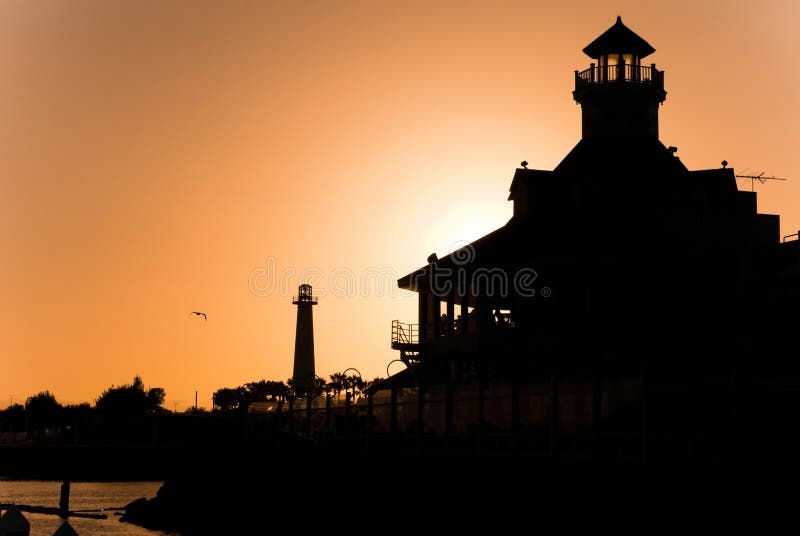 A sunset silhouette view of the Long Beach California lighthouse and marina district. A sunset silhouette view of the Long Beach California lighthouse and marina district.