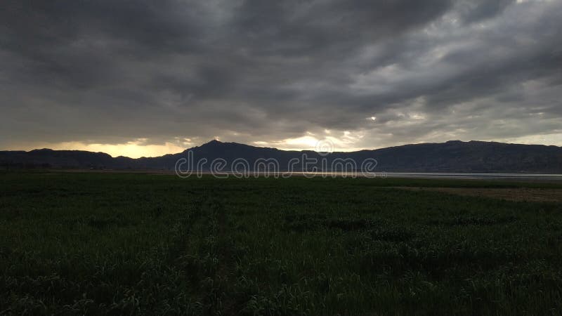 Puesta del sol en el lago detrás de las montañas imágenes de archivo libres de regalías Puesta del sol en el lago detrás de las montañas imágenes de archivo libres de regalías