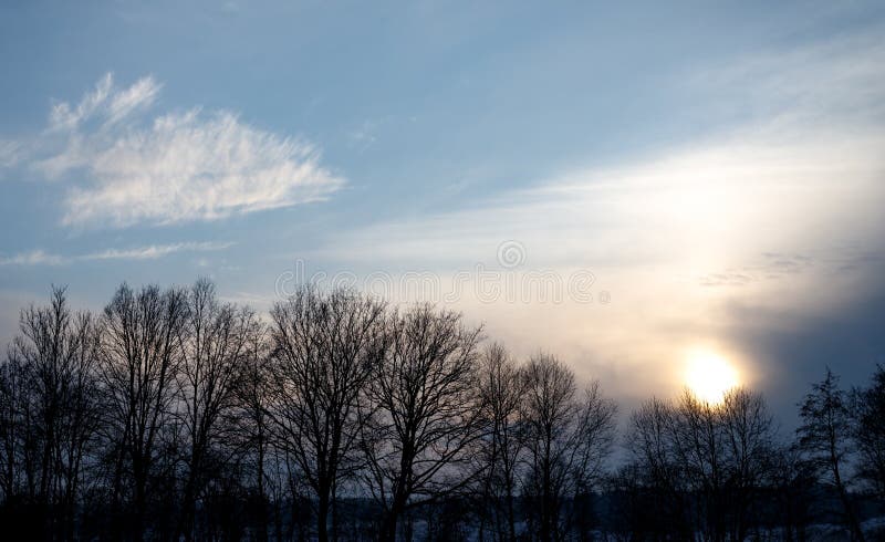 Puesta del sol impresionante en el invierno con las nubes y algunos árboles en las montañas europeas en un día frío en invierno fotografía de archivo Puesta del sol impresionante en el invierno con las nubes y algunos árboles en las montañas europeas en un día frío en invierno fotografía de archivo