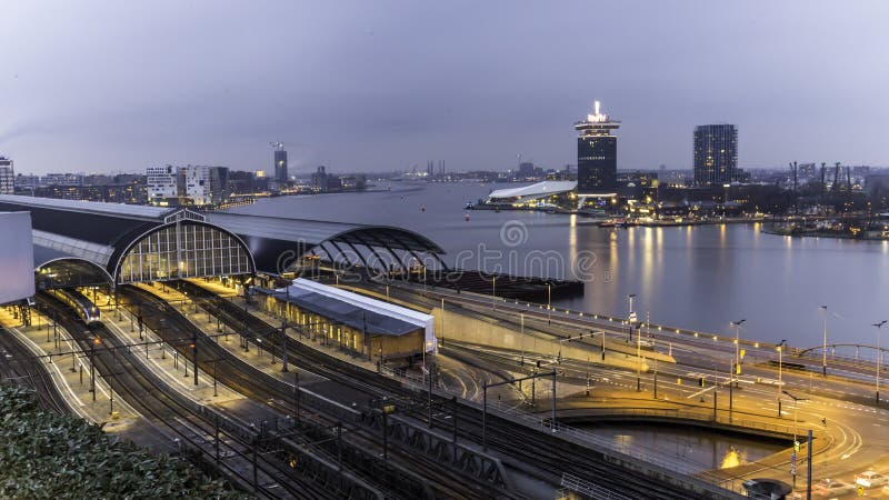 Puesta del sol del paisaje urbano de la estación de tren de Amsterdam imágenes de archivo libres de regalías Puesta del sol del paisaje urbano de la estación de tren de Amsterdam imágenes de archivo libres de regalías