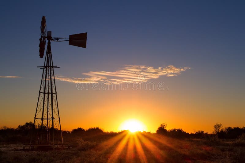 Puesta del sol preciosa en Kalahari con el molino de viento y la hierba imagenes de archivo Puesta del sol preciosa en Kalahari con el molino de viento y la hierba imagenes de archivo