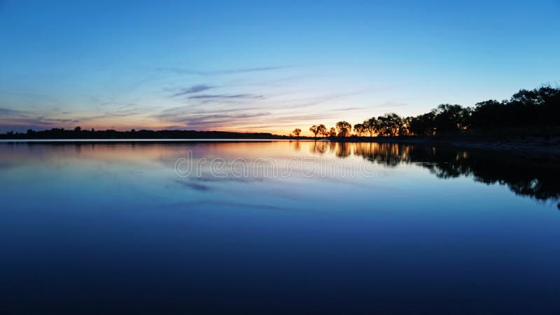 Puesta del sol que pasa por alto el lago, árboles, nubes El cielo y los arbustos se reflejan en el agua fotos de archivo libres de regalías Puesta del sol que pasa por alto el lago, árboles, nubes El cielo y los arbustos se reflejan en el agua fotos de archivo libres de regalías