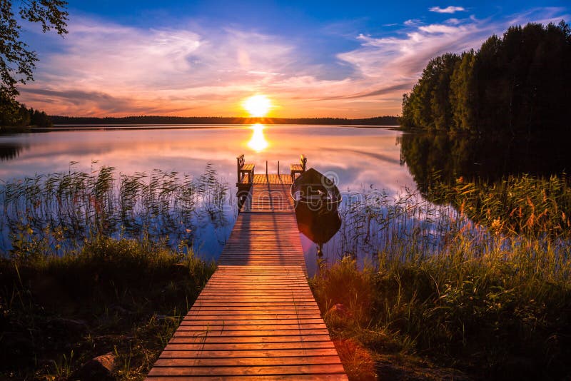 Puesta del sol sobre el embarcadero de la pesca en el lago en Finlandia fotografía de archivo libre de regalías