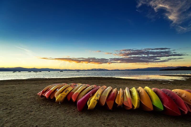 SOUTH LAKE TAHOE, CA - OCTOBER 7, 2015: Kayaks on the beach at South Lake Tahoe at sunset. SOUTH LAKE TAHOE, CA - OCTOBER 7, 2015: Kayaks on the beach at South Lake Tahoe at sunset.