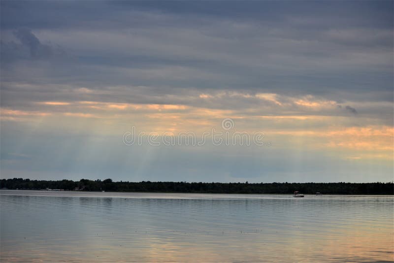 Puesta del sol a través de los cielos cubiertos sobre el lago Shawano en Wisconsin
