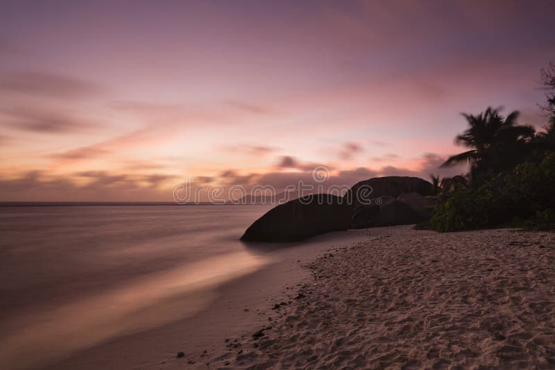 Colorful sunset long exposure at Anse Source D'Argent in La Digue, Seychelles with granite rocks in the foreground. Colorful sunset long exposure at Anse Source D'Argent in La Digue, Seychelles with granite rocks in the foreground