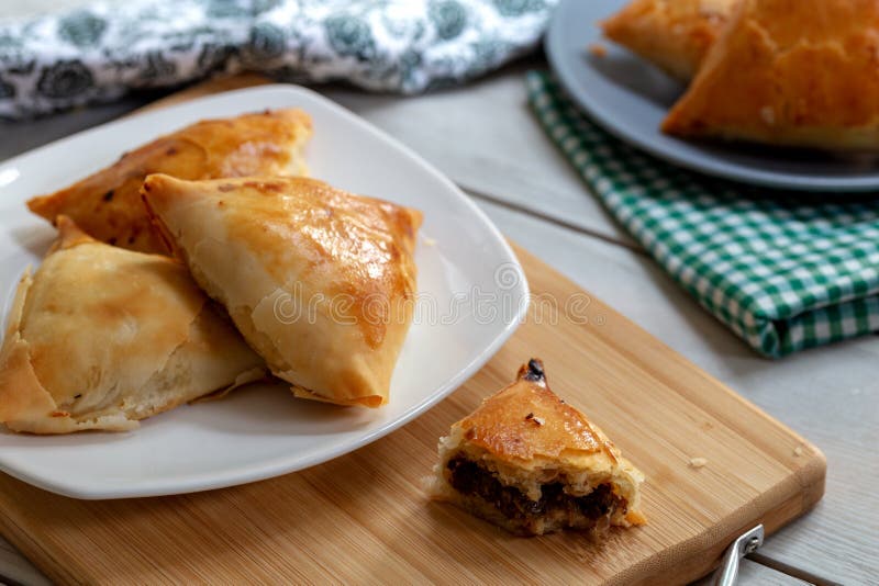 Puff pastry triangles filled minced meat, onion and spices stock photo