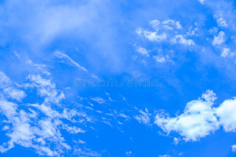 Small cumulus clouds passing by a very blue summer sky. royalty free stock photography