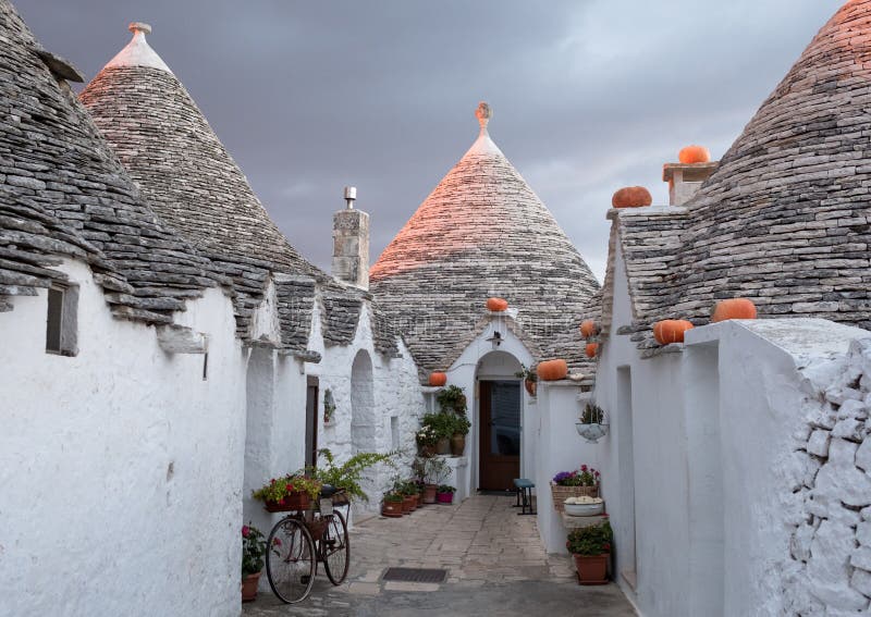 Puglia, Italy. Traditional conical roofed trulli houses on a street in Alberobello with pumpkins for halloween. royalty free stock images Puglia, Italy. Traditional conical roofed trulli houses on a street in Alberobello with pumpkins for halloween. royalty free stock images