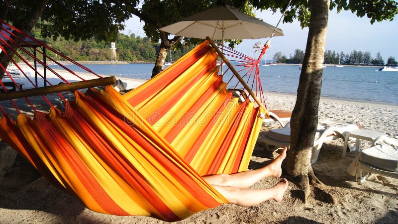 PULAU LANGKAWI, MALEISIË - 5 APRIL 2015: Vrouw het ontspannen in de hangmat bij het strand stock foto PULAU LANGKAWI, MALEISIË - 5 APRIL 2015: Vrouw het ontspannen in de hangmat bij het strand stock foto