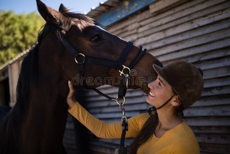 Puleggia tenditrice femminile felice che segna cavallo fotografie stock libere da diritti Puleggia tenditrice femminile felice che segna cavallo fotografie stock libere da diritti