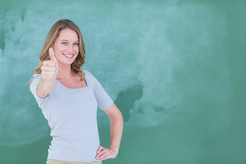 Pulgares derechos sonrientes del profesor para arriba delante de la pizarra imagen de archivo Pulgares derechos sonrientes del profesor para arriba delante de la pizarra imagen de archivo