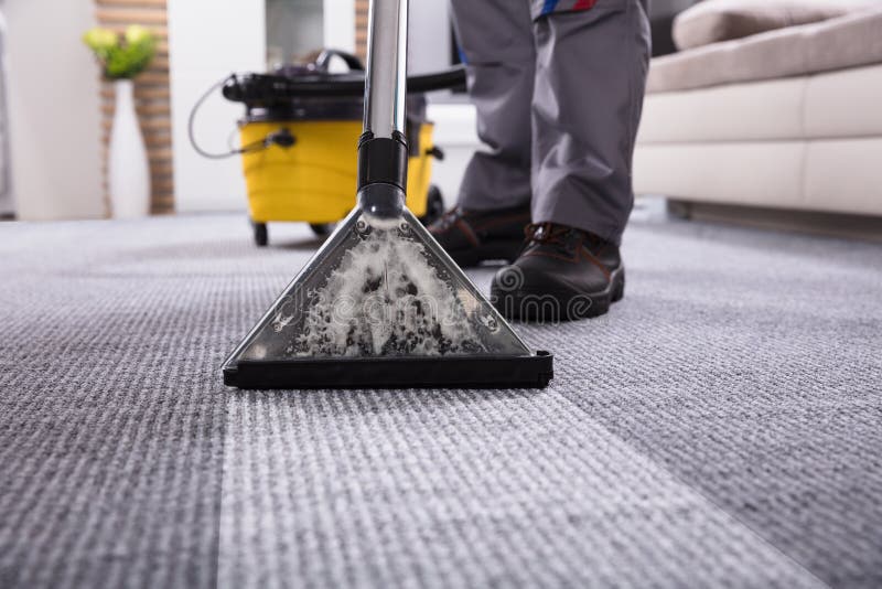 Pulitore di Person Cleaning Carpet With Vacuum