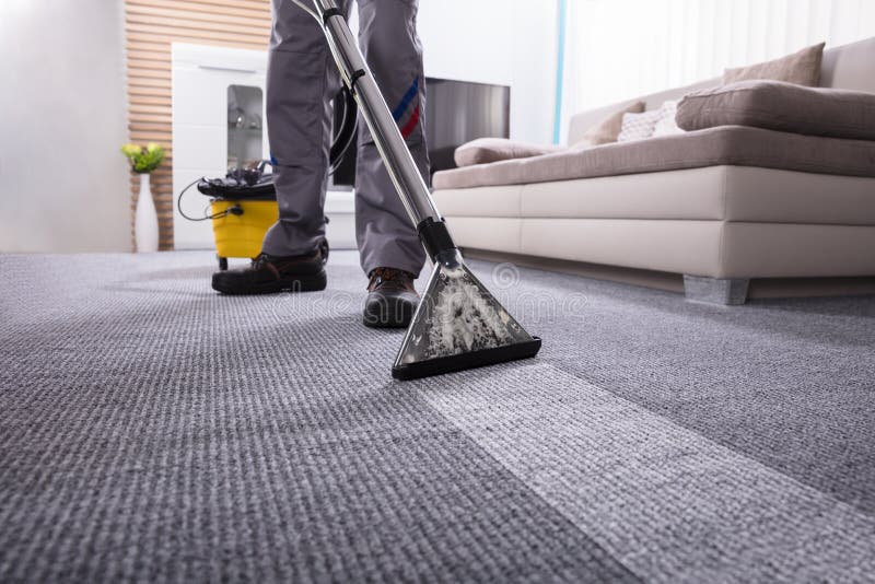 Low Section Of A Person Cleaning The Carpet With Vacuum Cleaner In ving Room. Low Section Of A Person Cleaning The Carpet With Vacuum Cleaner In ving Room