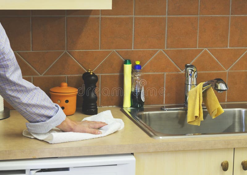 Man's hand with cotton towel wiping kitchen counter. Man's hand with cotton towel wiping kitchen counter