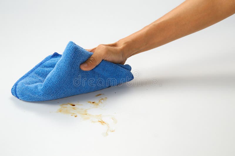 Hand holding cloth cleaning white table top. Hand holding cloth cleaning white table top