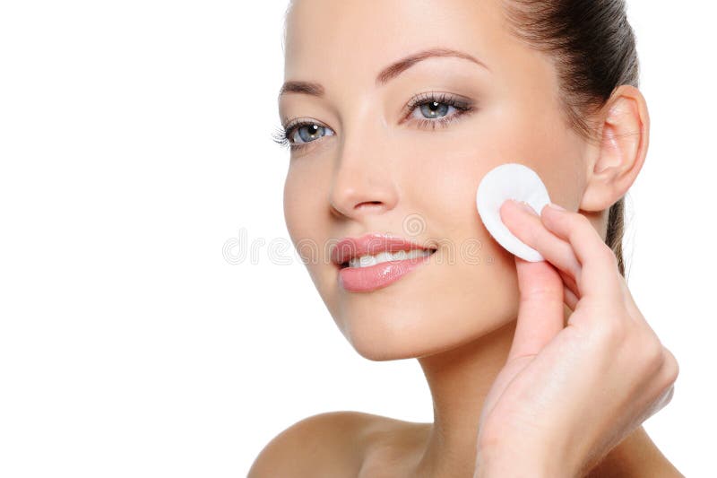 Pulizia della donna di bellezza il suo fronte con il tampone di cotone immagine stock libera da diritti Pulizia della donna di bellezza il suo fronte con il tampone di cotone immagine stock libera da diritti