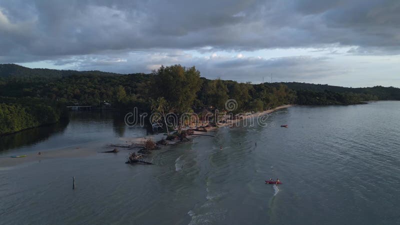 Evening atmosphere on the sandbank, beach bar. Smooth aerial view flight drone