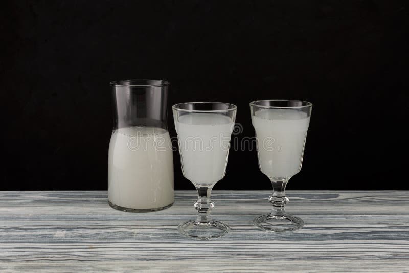 Pulque or pulke in drinking glasses on dark background. Traditional mexican beverage made from fermented sap of maguey agave