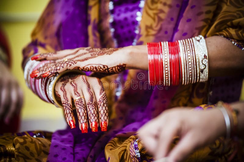 Punjabi bride's hands, fully decorated with henna decoration wearing bangle bracelet on her wedding day. Punjabi bride's hands, fully decorated with henna decoration wearing bangle bracelet on her wedding day