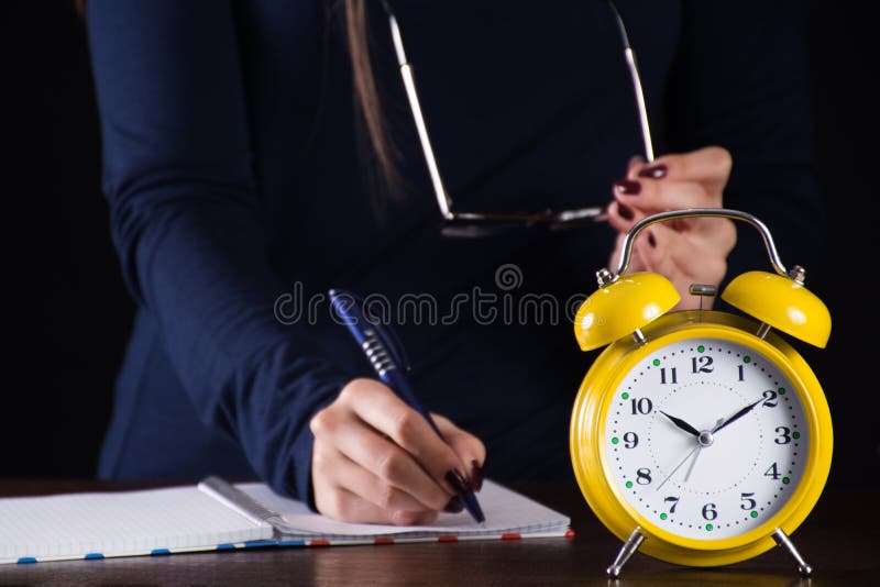 Pulso de disparo análogo retro velho e menina do alarme amarelo na escrita do fundo fotografia de stock Pulso de disparo análogo retro velho e menina do alarme amarelo na escrita do fundo fotografia de stock
