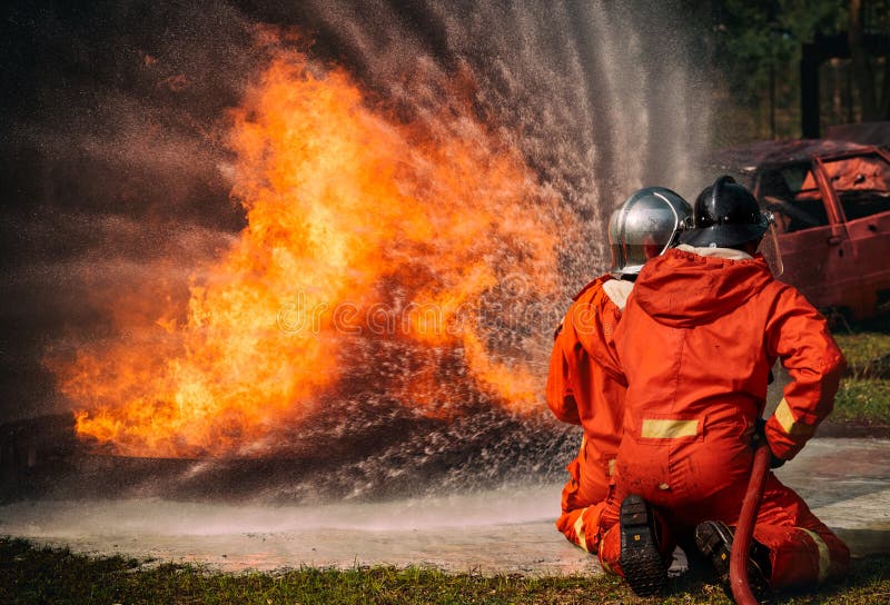 Pulverizador de água dos sapadores-bombeiros pelo bocal de alta pressão no fogo, fotos de stock royalty free Pulverizador de água dos sapadores-bombeiros pelo bocal de alta pressão no fogo, fotos de stock royalty free