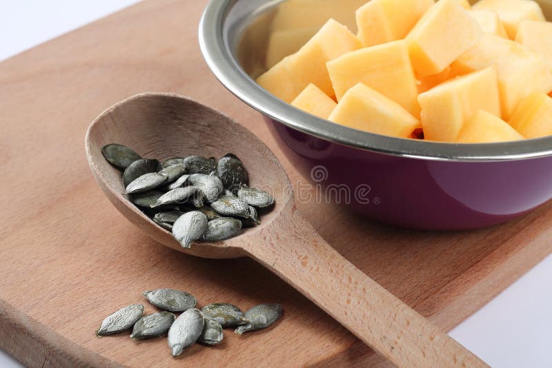 Pumpa i kernels för en bunke och pumpai en sked royaltyfri fotografi Pumpa i kernels för en bunke och pumpai en sked royaltyfri fotografi