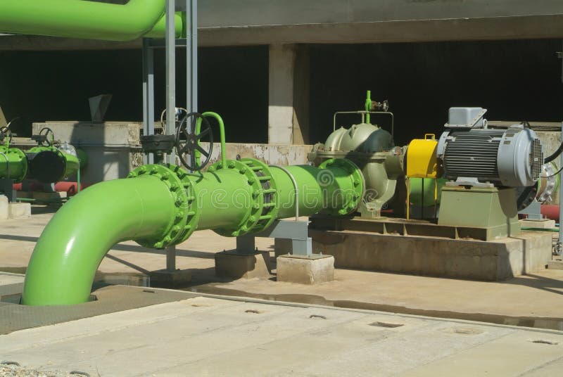 Pumps, valves and green steel pipes at industrial cooling tower. Pumps, valves and green steel pipes at industrial cooling tower.