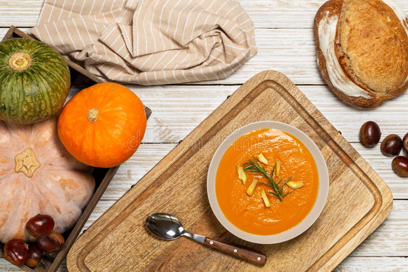 Pumpkin and chestnut soup with rosemary twig aside bread loaf, entire pumpkins and chestnuts in a crate on a white vintage wood stock photos Pumpkin and chestnut soup with rosemary twig aside bread loaf, entire pumpkins and chestnuts in a crate on a white vintage wood stock photos