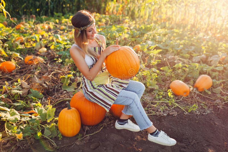 Pumpkin Harvest. Young Woman Farmer Picking Autumn Crop of Pumpkins on ...