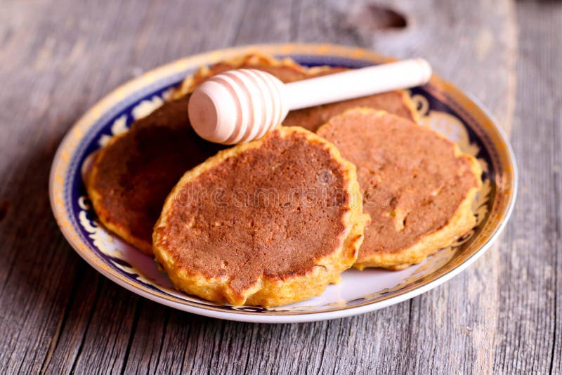 Pumpkin pancakes on a plate for breakfast with honey, horizontal