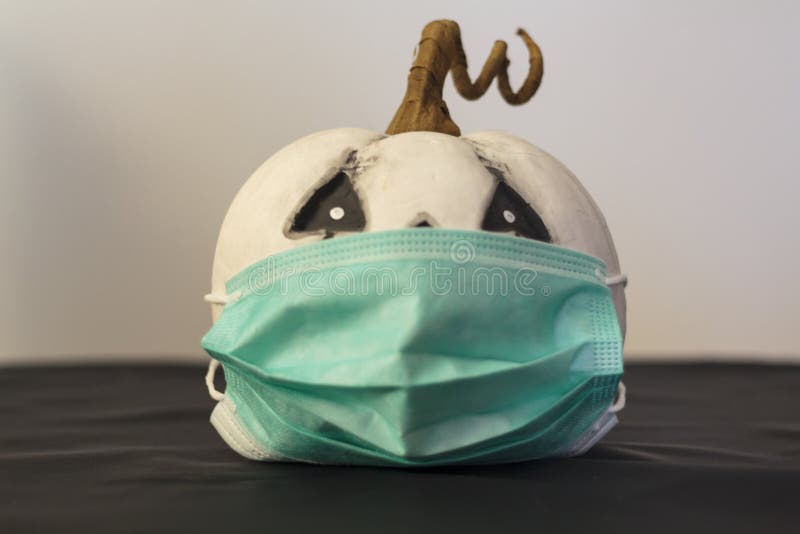 Pumpkin with Protective Face Mask. Concept of Halloween during Covid19
