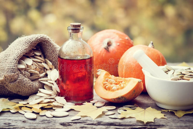 Pumpkin seeds oil bottle, pumpkins, bag with seeds and mortar