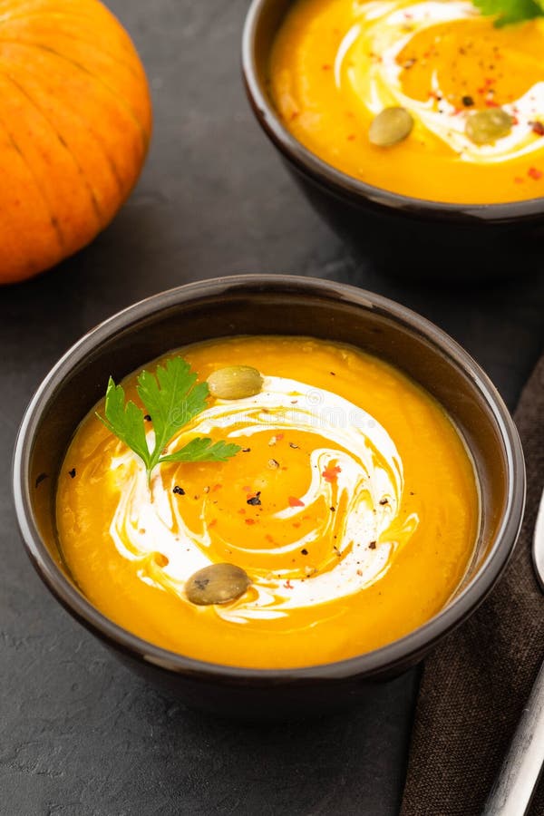 Pumpkin Soup In A Bowl With Fresh Pumpkins, Garlic And Parsley Herbs On ...