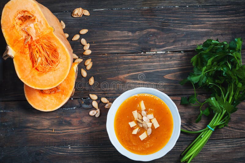 Bowl of Pumpkin Soup with Bread Crouton on Wood Table Stock Photo