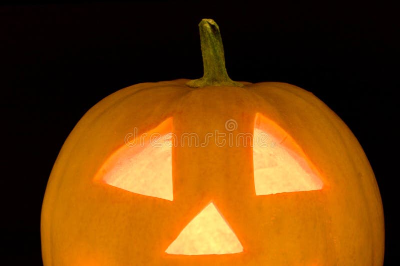 Closeup of halloween pumplin lightened face on black background. Closeup of halloween pumplin lightened face on black background