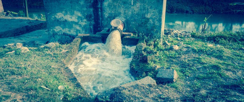 Pumpsystem för panoramabaserad bevattning med bubblor som flödar på vatten från en rustik ledning i Vietnam arkivbilder