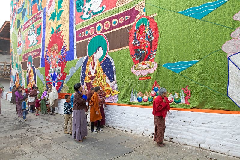 Bhutanese people in traditional clothes are paying tribute at the Avalokitesvara, compassion of all Buddhas, displayed along the tower of the dzong, utse, during the birth anniversary ceremony of the 4th King at the Punakha Dzong, Punakha, Bhutan. The image of Avalokitesvara is enshrined in the utse of the dzong and displaye during the festival. The Dzong was built in 1637-38 by Ngawang Namgyal, 1. Bhutanese people in traditional clothes are paying tribute at the Avalokitesvara, compassion of all Buddhas, displayed along the tower of the dzong, utse, during the birth anniversary ceremony of the 4th King at the Punakha Dzong, Punakha, Bhutan. The image of Avalokitesvara is enshrined in the utse of the dzong and displaye during the festival. The Dzong was built in 1637-38 by Ngawang Namgyal, 1