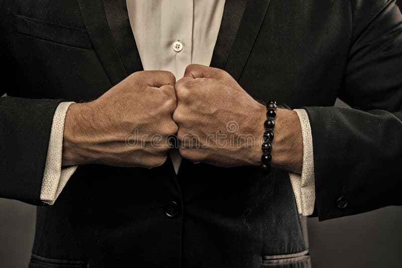 Punhos masculinos com veias e o bracelete inchados no fundo formal do terno Conceito da confronta??o M?o da pessoa do neg?cio foto de stock royalty free Punhos masculinos com veias e o bracelete inchados no fundo formal do terno Conceito da confronta??o M?o da pessoa do neg?cio foto de stock royalty free