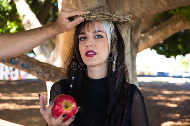 Punky Girl With Blonde And Brunette Hair Holding A Red Apple In Her