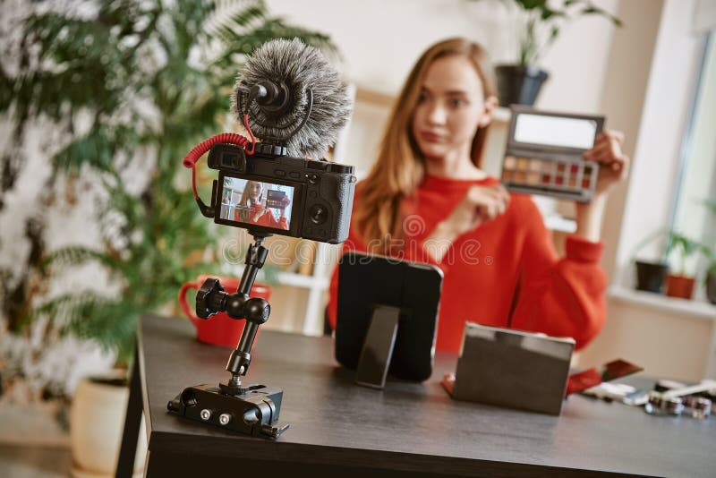 Punte di bellezza Giovane donna attraente che mostra una tavolozza di trucco sulla macchina fotografica mentre registrando video fotografia stock Punte di bellezza Giovane donna attraente che mostra una tavolozza di trucco sulla macchina fotografica mentre registrando video fotografia stock