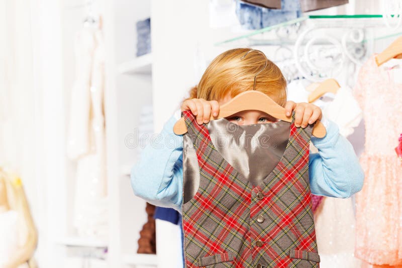 Punto di vista del primo piano del ragazzo che si nasconde dietro il gancio e la maglia immagini stock Punto di vista del primo piano del ragazzo che si nasconde dietro il gancio e la maglia immagini stock