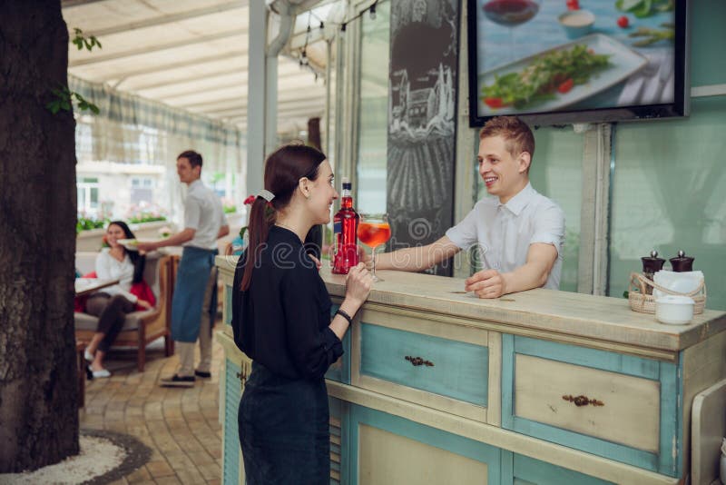Punto di vista dell'uomo che sta al contatore della barra e che fa cocktail per la donna che resta vicino fotografie stock libere da diritti Punto di vista dell'uomo che sta al contatore della barra e che fa cocktail per la donna che resta vicino fotografie stock libere da diritti