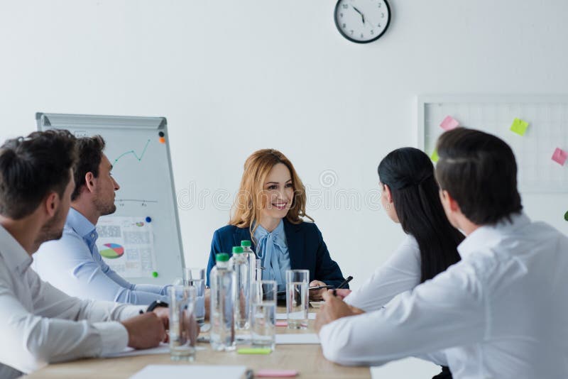 punto di vista parziale dei colleghi di affari che hanno discussione nel luogo di lavoro immagine stock punto di vista parziale dei colleghi di affari che hanno discussione nel luogo di lavoro immagine stock