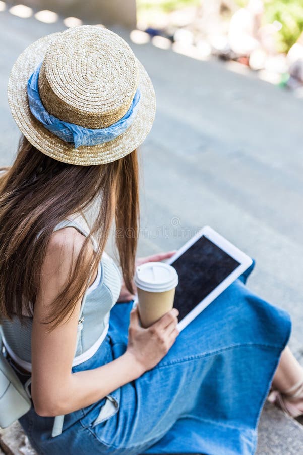 punto di vista parziale della donna con la compressa ed il caffè da andare sedersi sui punti sulla via immagine stock punto di vista parziale della donna con la compressa ed il caffè da andare sedersi sui punti sulla via immagine stock