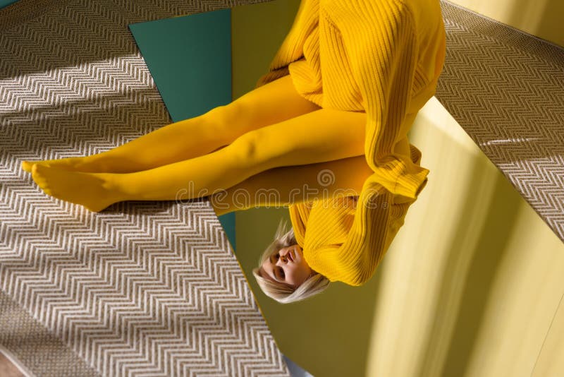 punto di vista parziale della donna in maglione giallo e calzamaglia che si siedono sullo specchio con la riflessione immagini stock libere da diritti punto di vista parziale della donna in maglione giallo e calzamaglia che si siedono sullo specchio con la riflessione immagini stock libere da diritti
