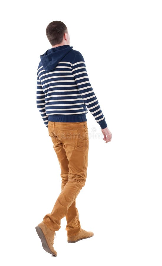 Punto di vista posteriore dell'uomo bello di camminata in jeans e maglione a strisce fotografia stock libera da diritti